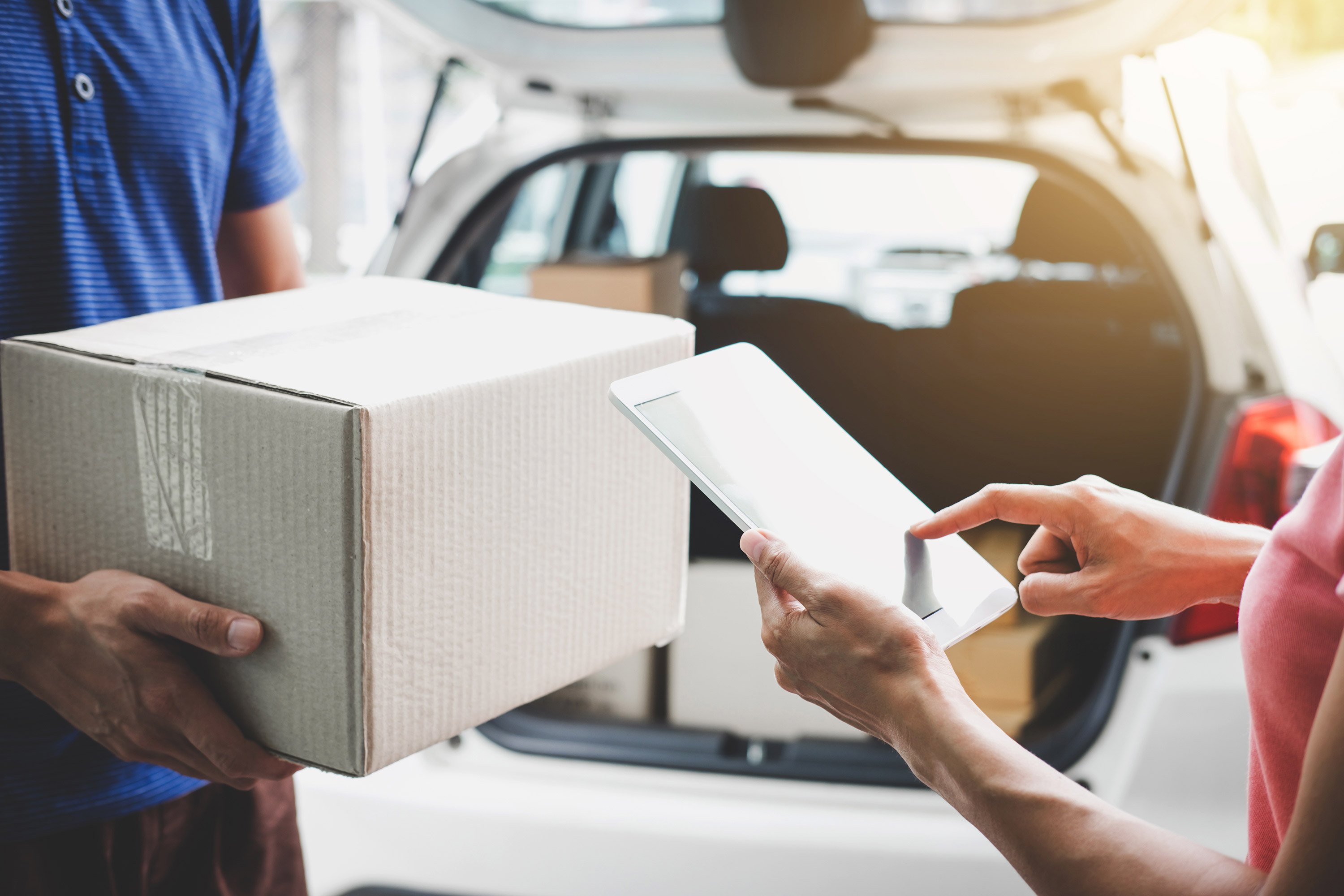 Woman customer appending signature in digital tablet and receiving a cardboard boxes parcel from delivery service courier, Home delivery service and working.