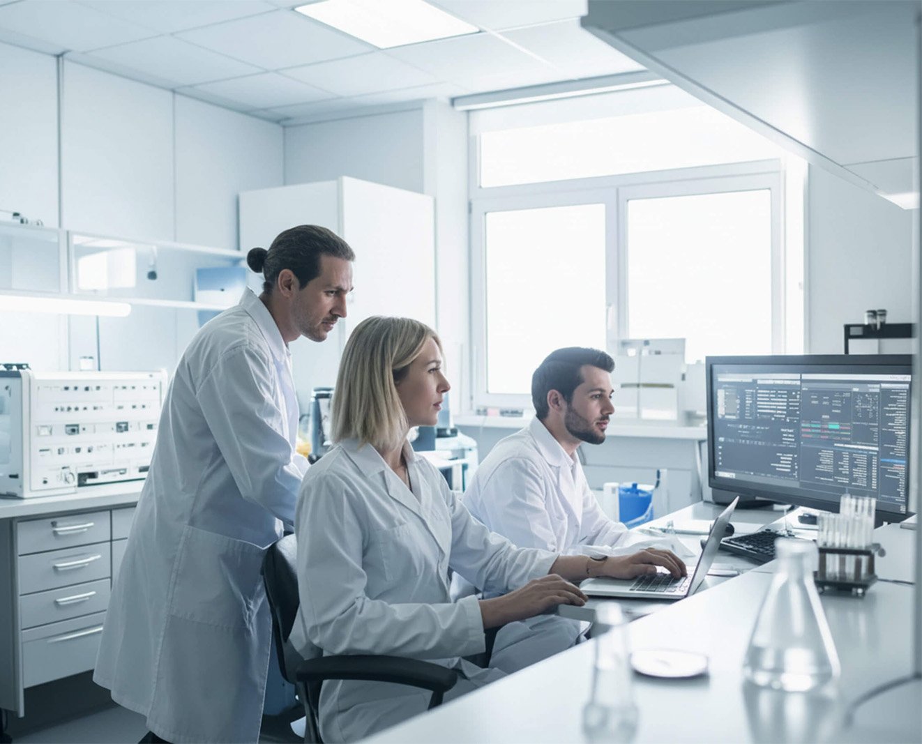Laboratory team reviewing data on a computer screen.