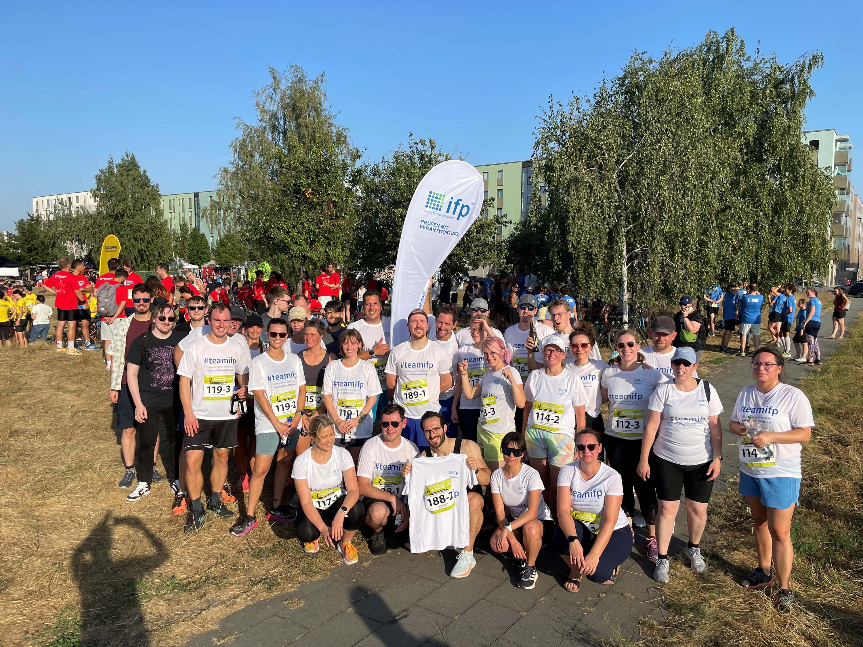 Group of ifp team members posing together at an outdoor running event.