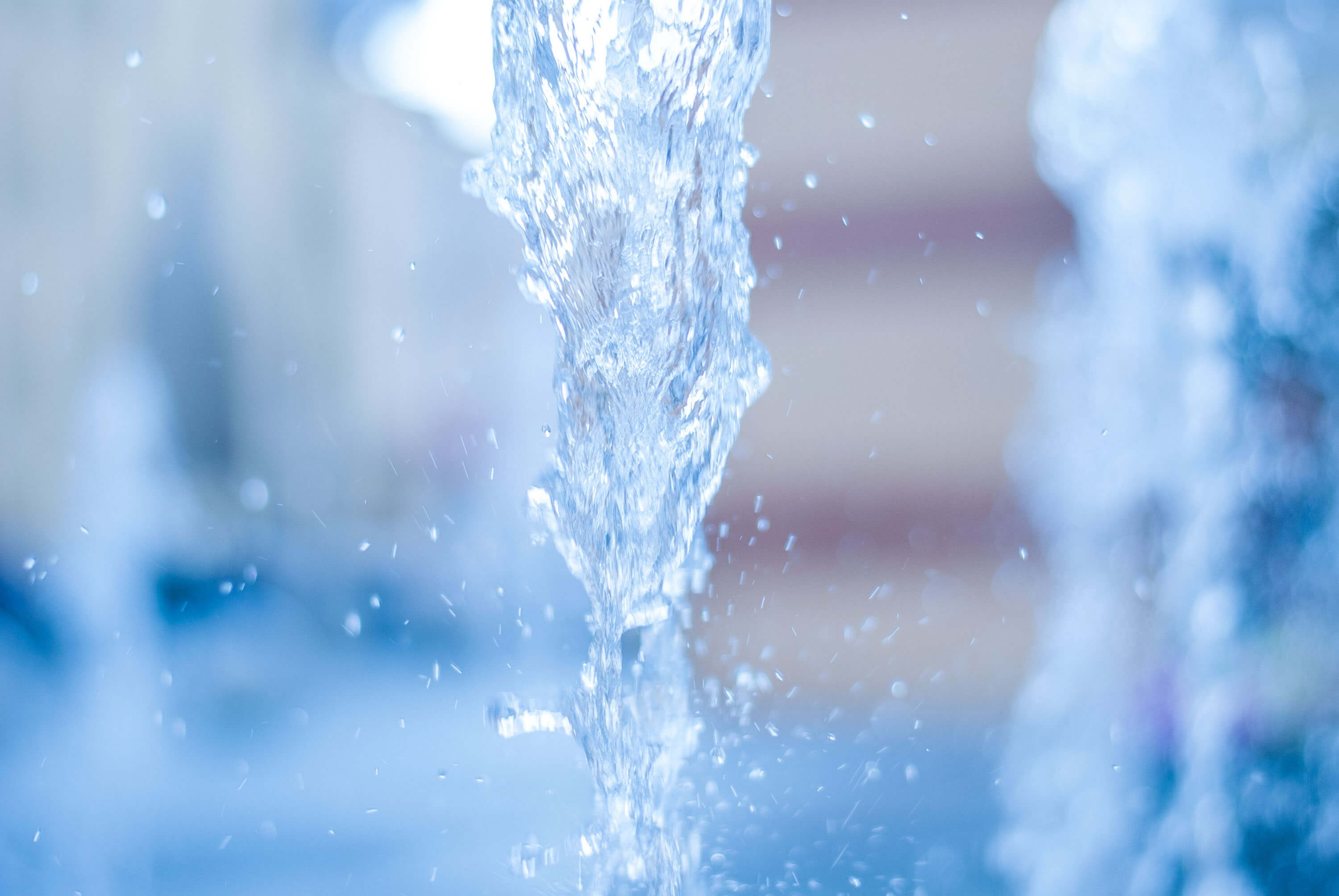 Close-up of flowing fountain water with splashing droplets.
