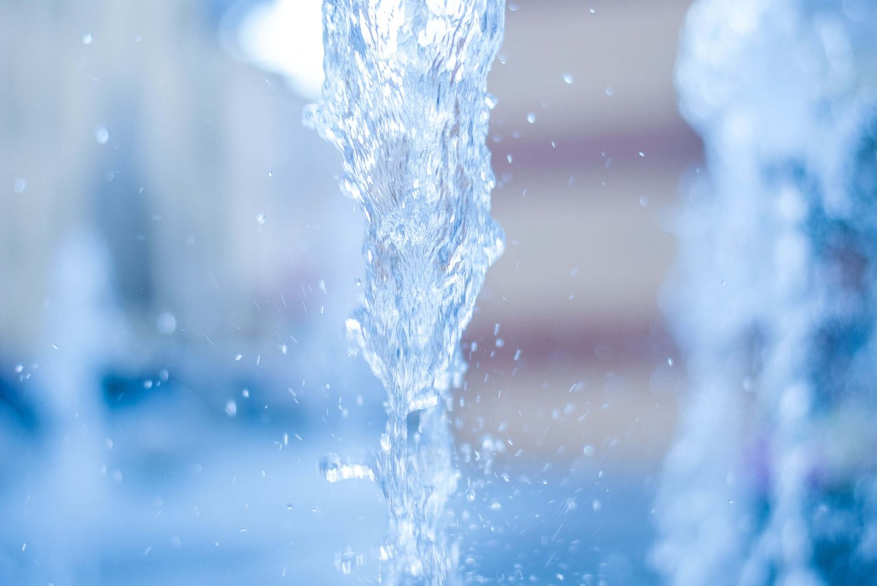 Close-up of flowing fountain water with splashing droplets.
