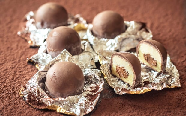 Chocolate truffles rest on cocoa powder.
