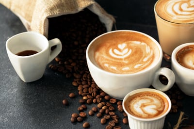 Espresso and coffee cups with coffee beans in Background.