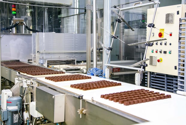 Sweets move along a conveyor belt during the production process in a factory.