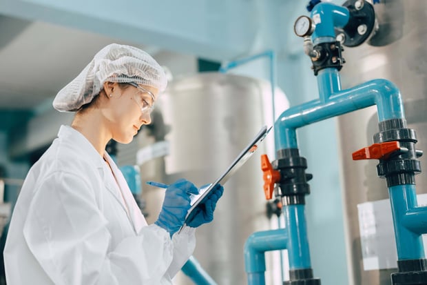 A factory worker monitors valves and water pipes during the drinking water purification process.