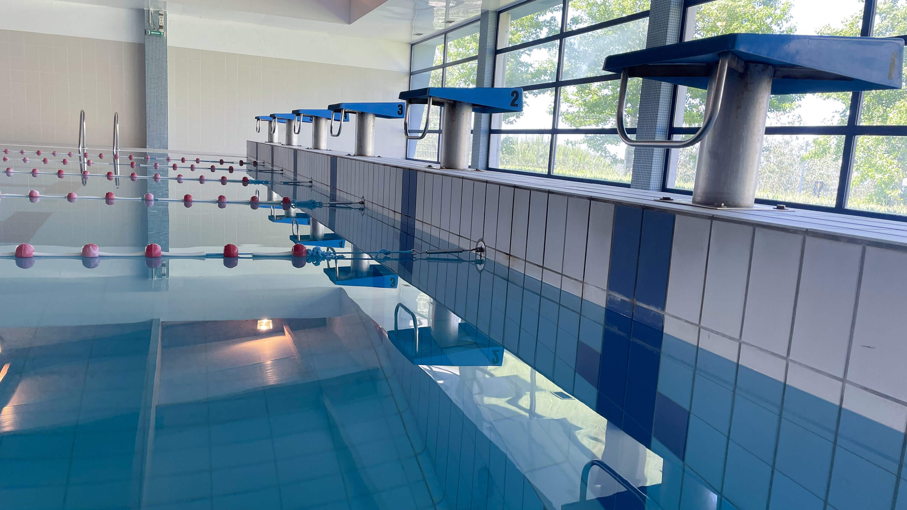 Swimming pool with blue water and swimming lanes, diving boards for participation in water competitions.