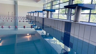 Swimming pool with blue water and swimming lanes, diving boards for participation in water competitions.
