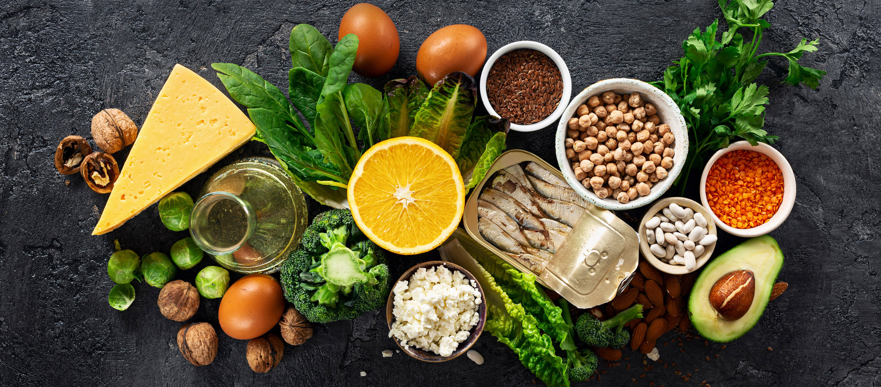 Top view of foods rich in omega-3 and healthy fats on a dark background.