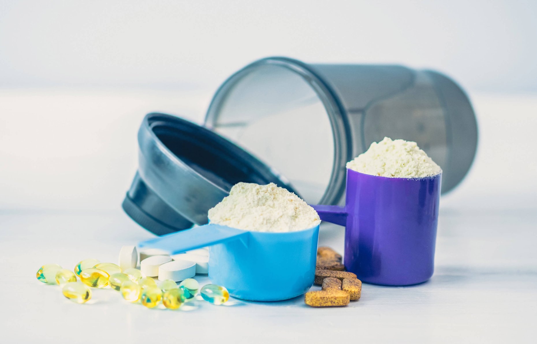 Sport food supplements. Sport Pills, vitamins and protein powder on the white table.