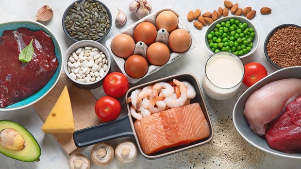 Several bowls containing a variety of foods such as meat, eggs, fish, vegetables, and nuts.