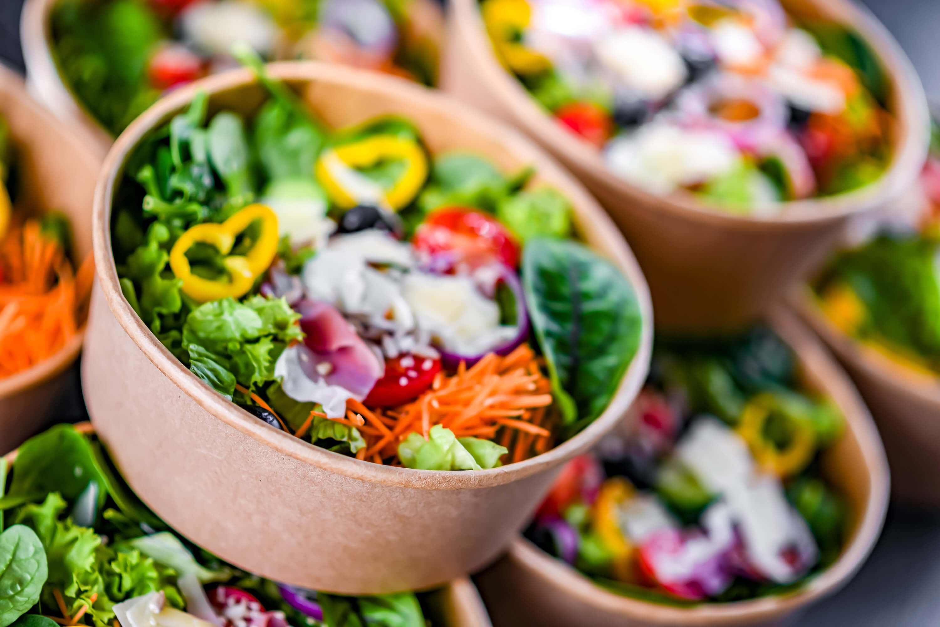 Paper boxes with pre-packaged vegetable salads ready for sale.