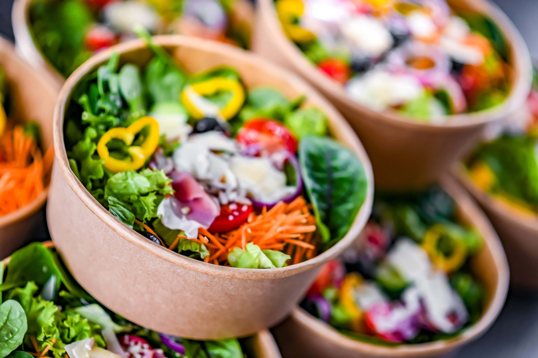 Paper boxes with pre-packaged vegetable salads ready for sale.