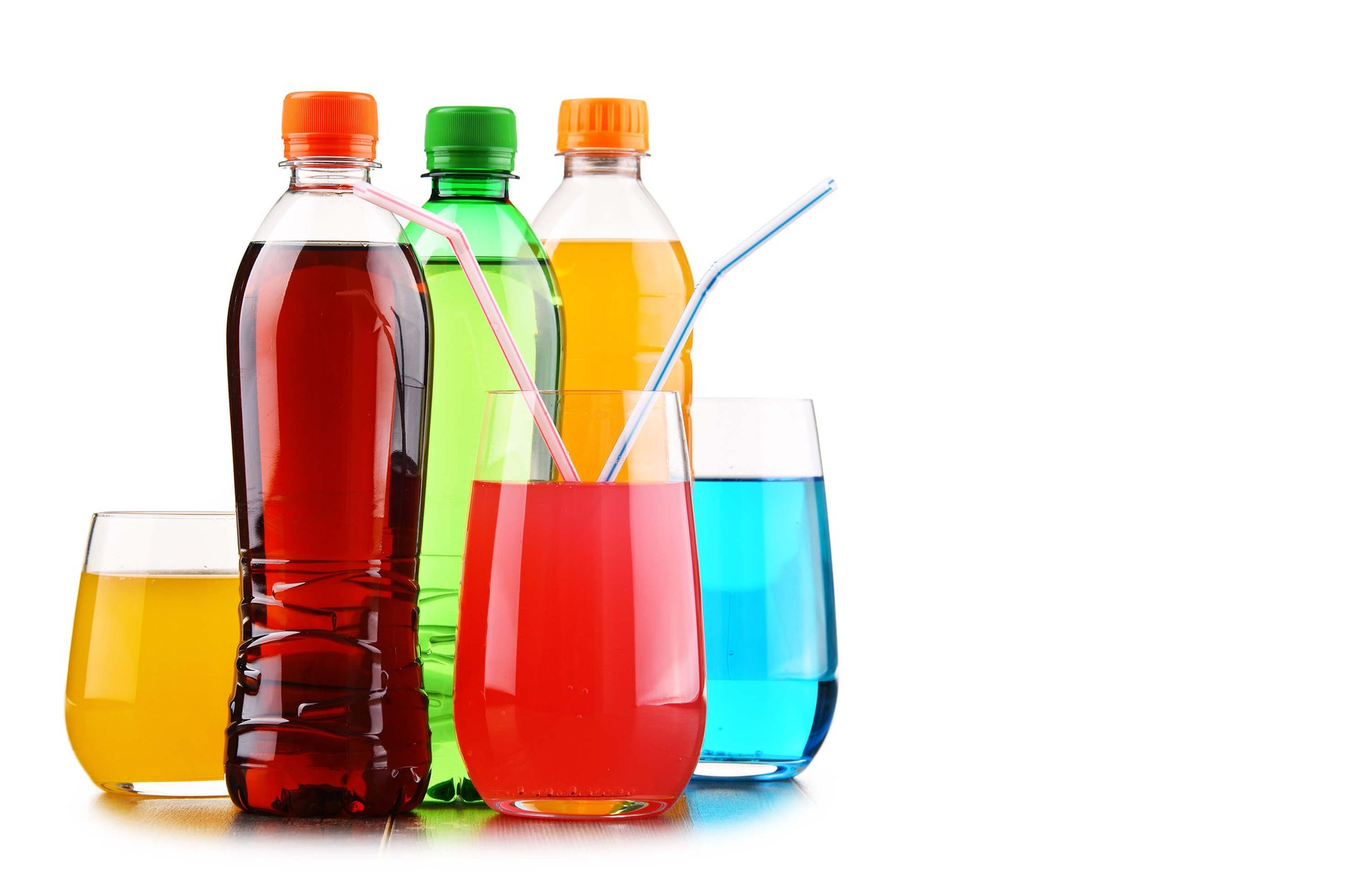 Glasses and bottles of assorted carbonated soft drinks.