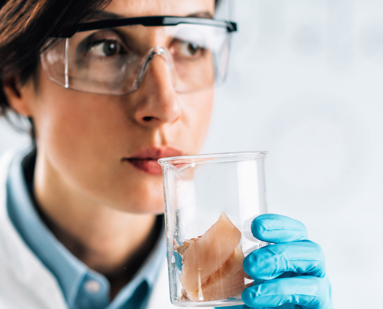 Food safety inspector smelling a sample in a laboratory.