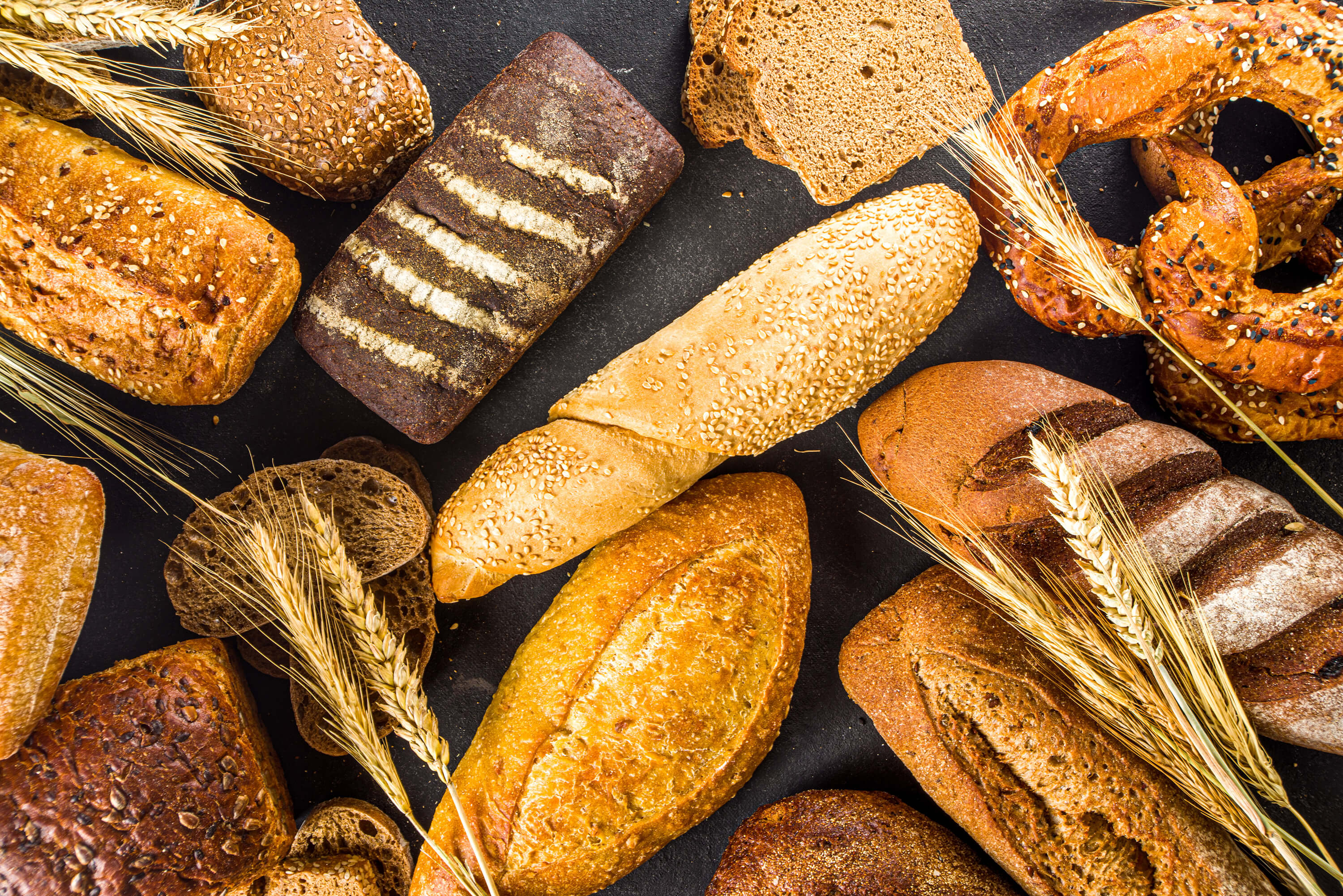 Top view of assorted baked goods on a dark surface.