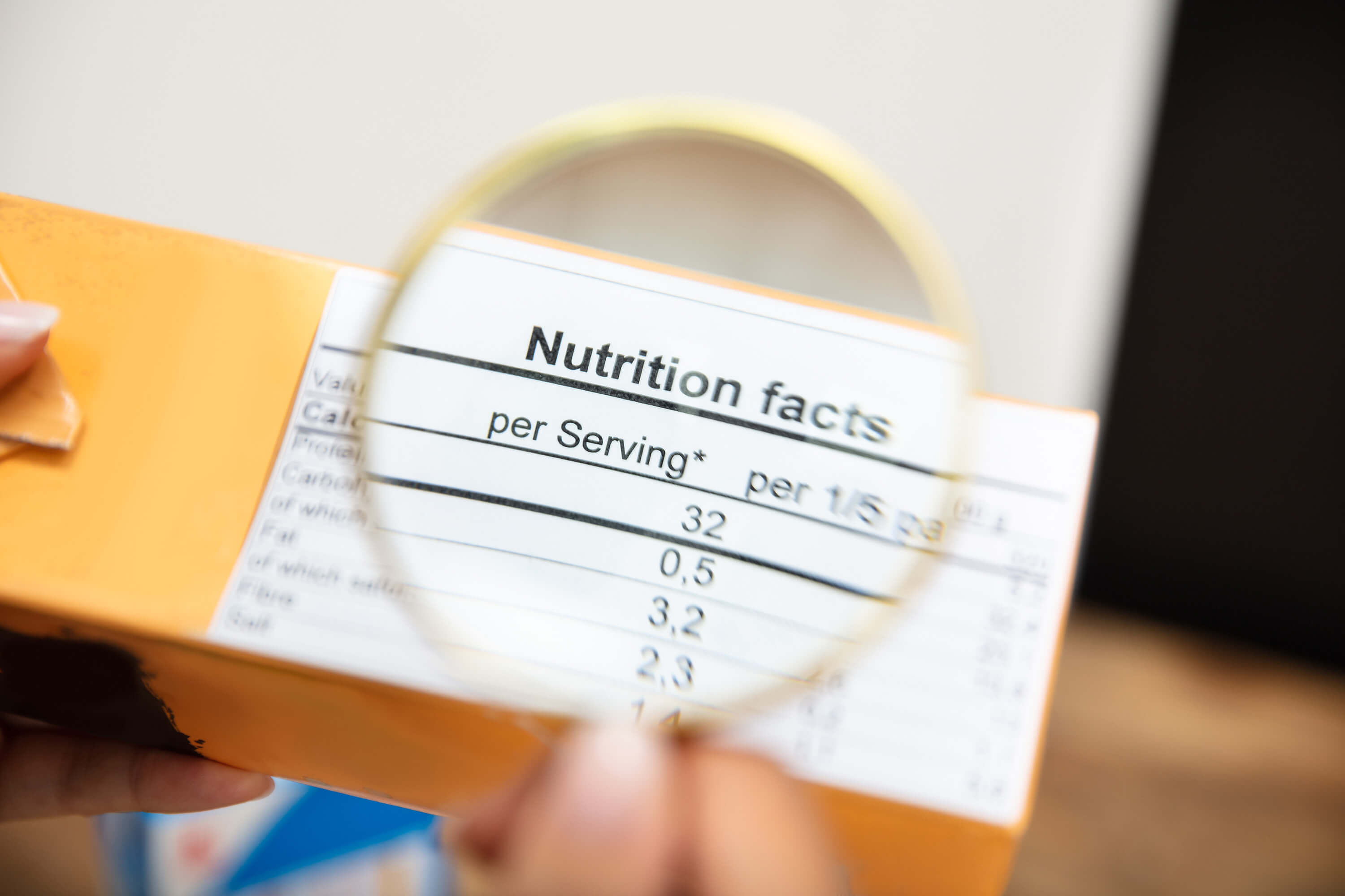 Magnifying glass over a nutrition facts label on food packaging.