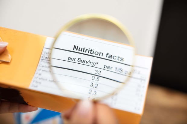 Magnifying glass over a nutrition facts label on food packaging.