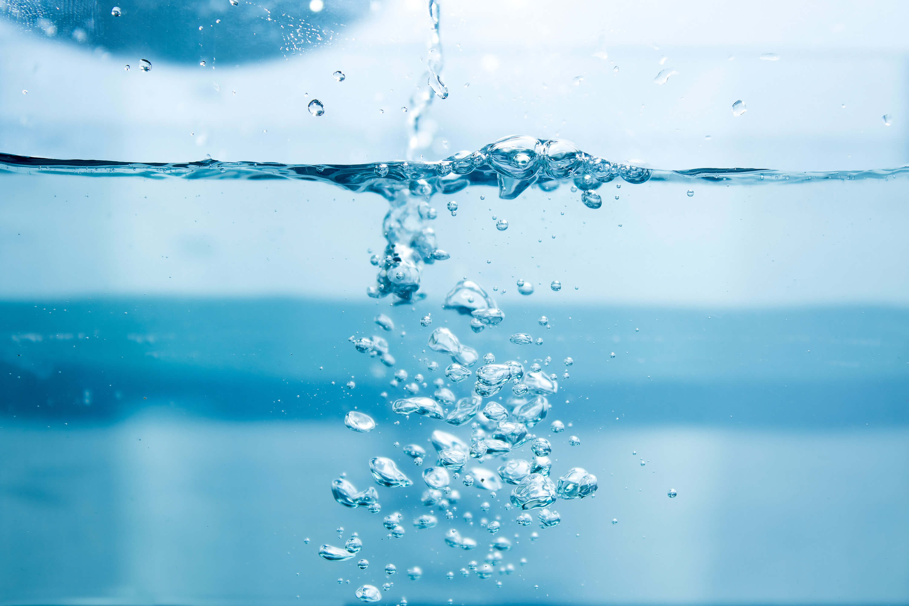 Water is poured into a glass, creating soap bubbles.
