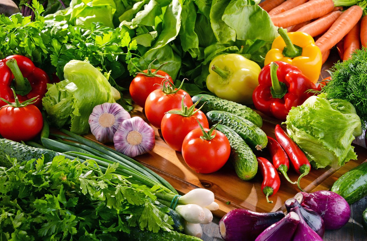 Composition with variety of fresh organic vegetables and fruits.