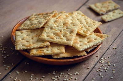 Crispy crackers with sesame on wooden plate.