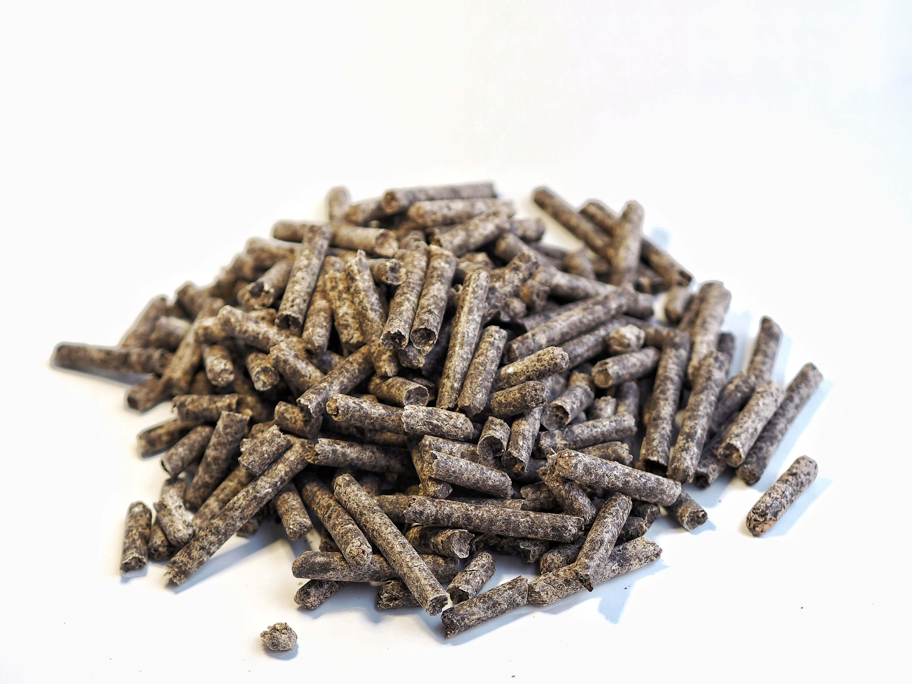 A pile of beetroot pellets as a renewable animal feed source on a white background.