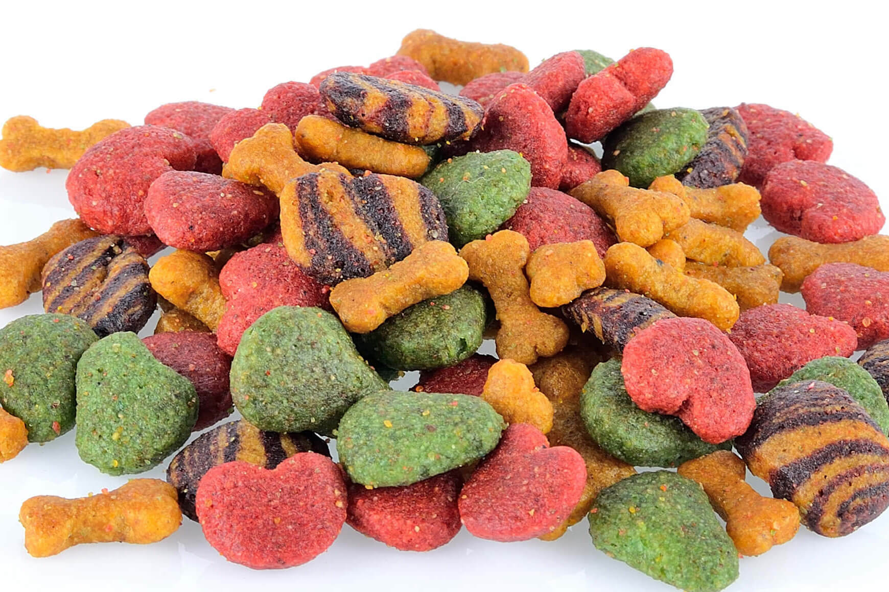 Colorful pet food pieces in various shapes are arranged on a white background.