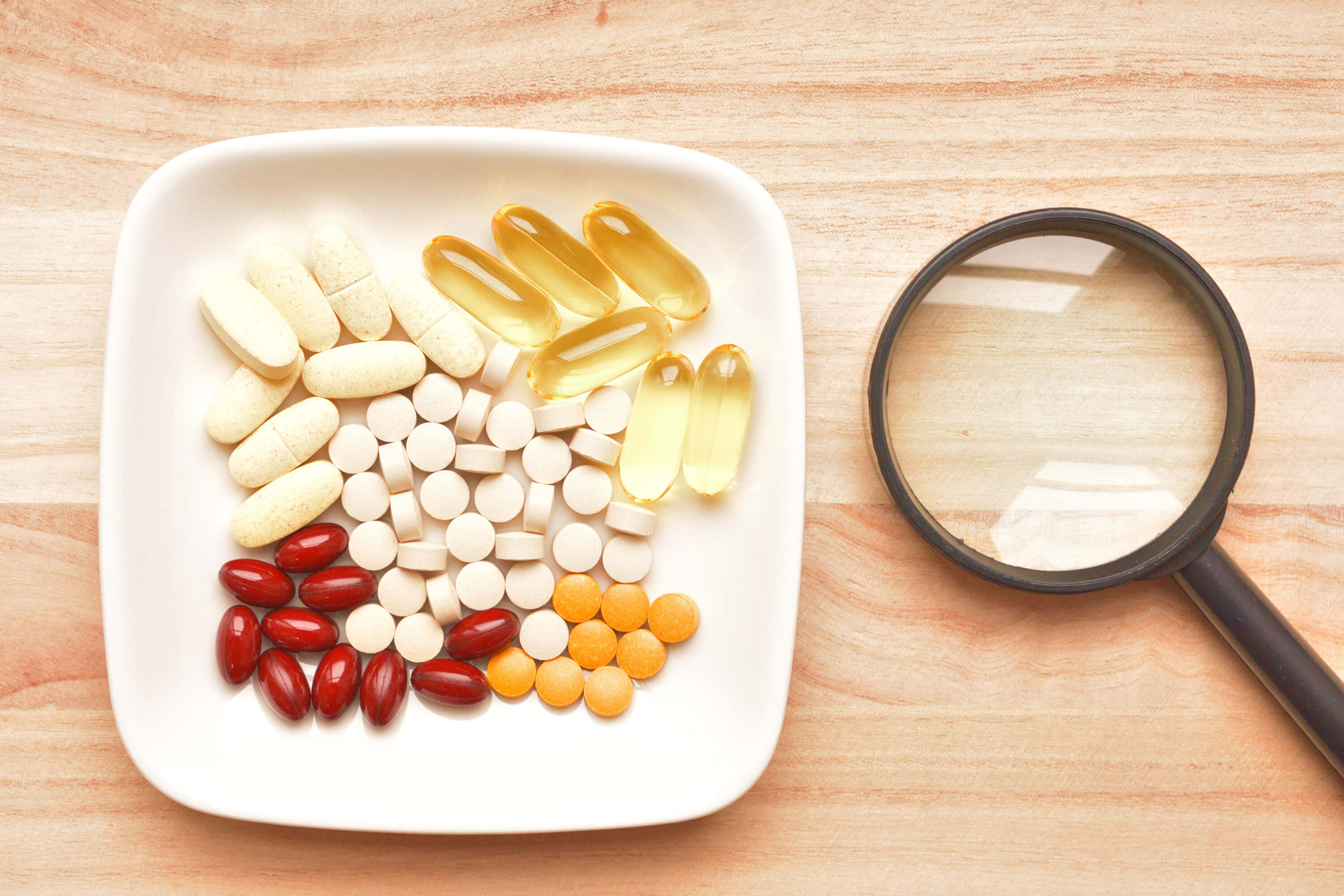 A plate filled with assorted pills and vitamins, representing various food supplements for health and wellness.