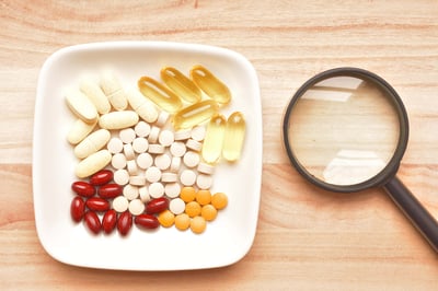 A plate filled with assorted pills and vitamins, representing various food supplements for health and wellness.