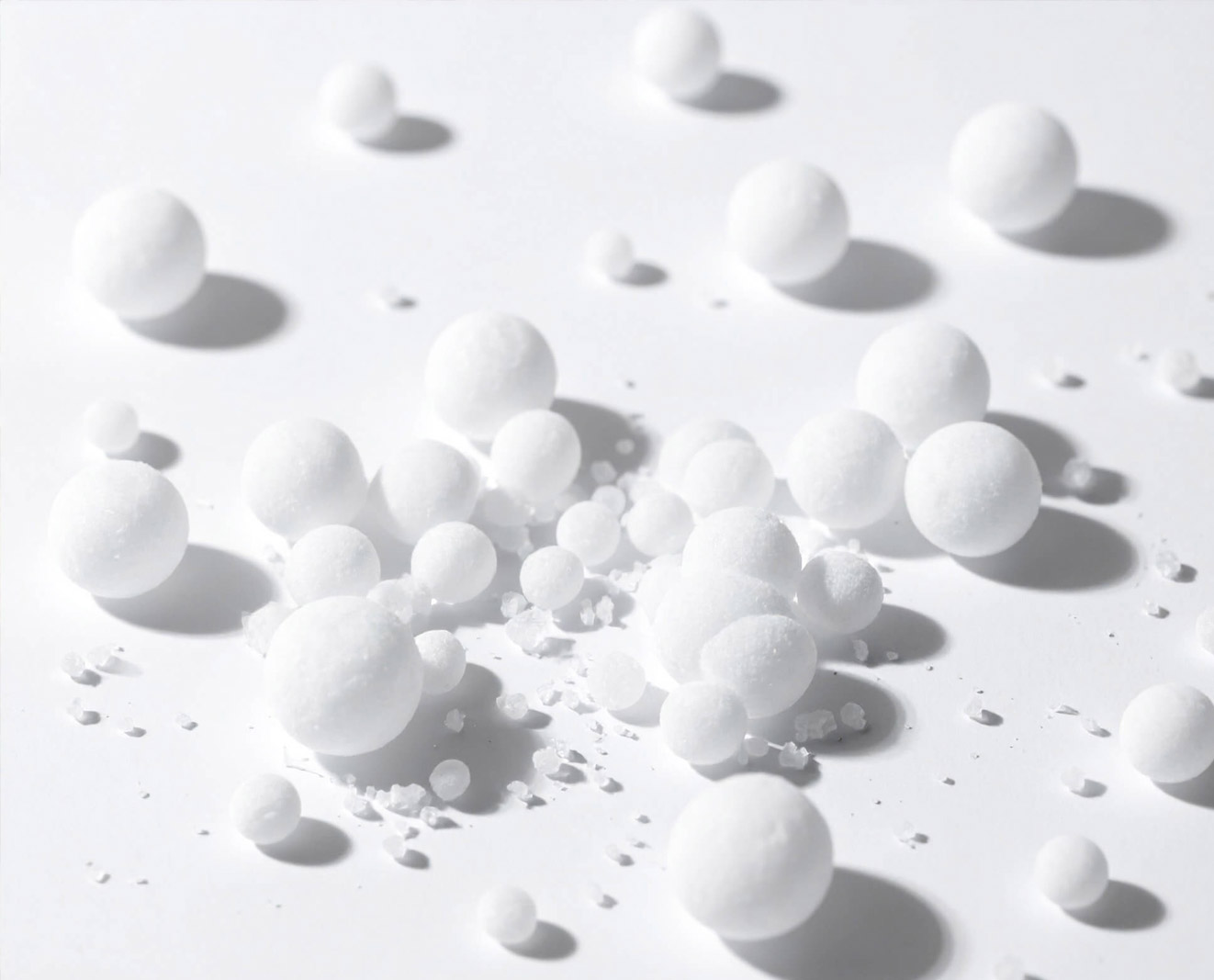 Numerous small white spheres are scattered across a white background.