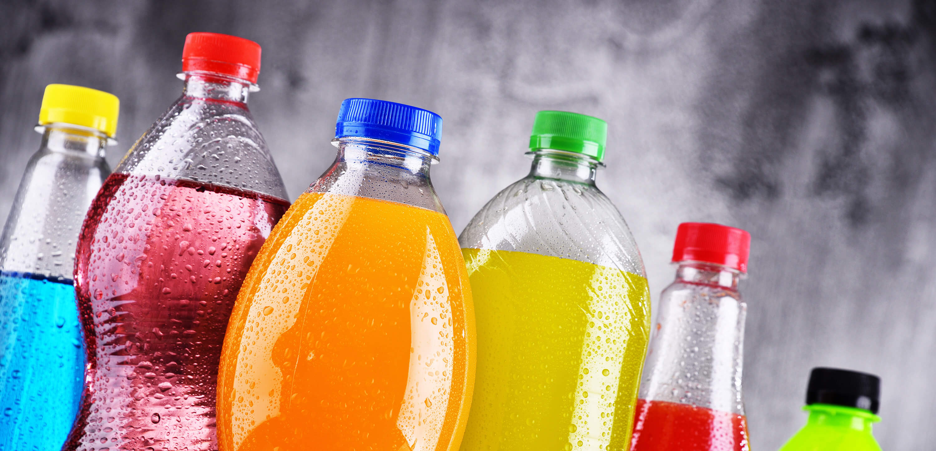 A display of colorful soda bottles, showcasing a variety of hues and designs.
