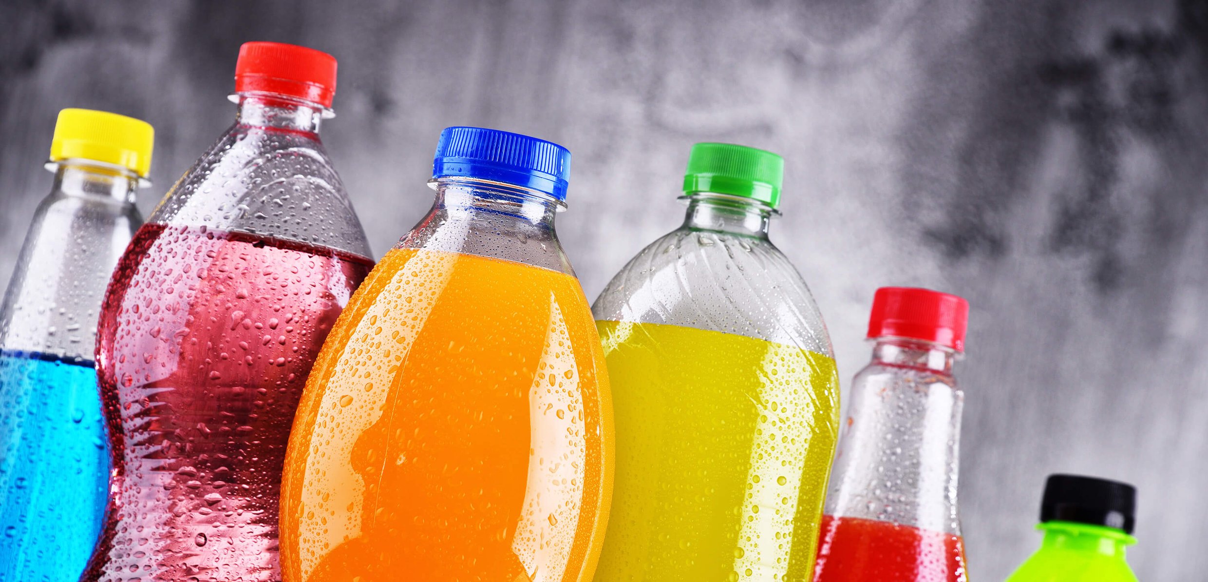 A display of colorful soda bottles, showcasing a variety of hues and designs.