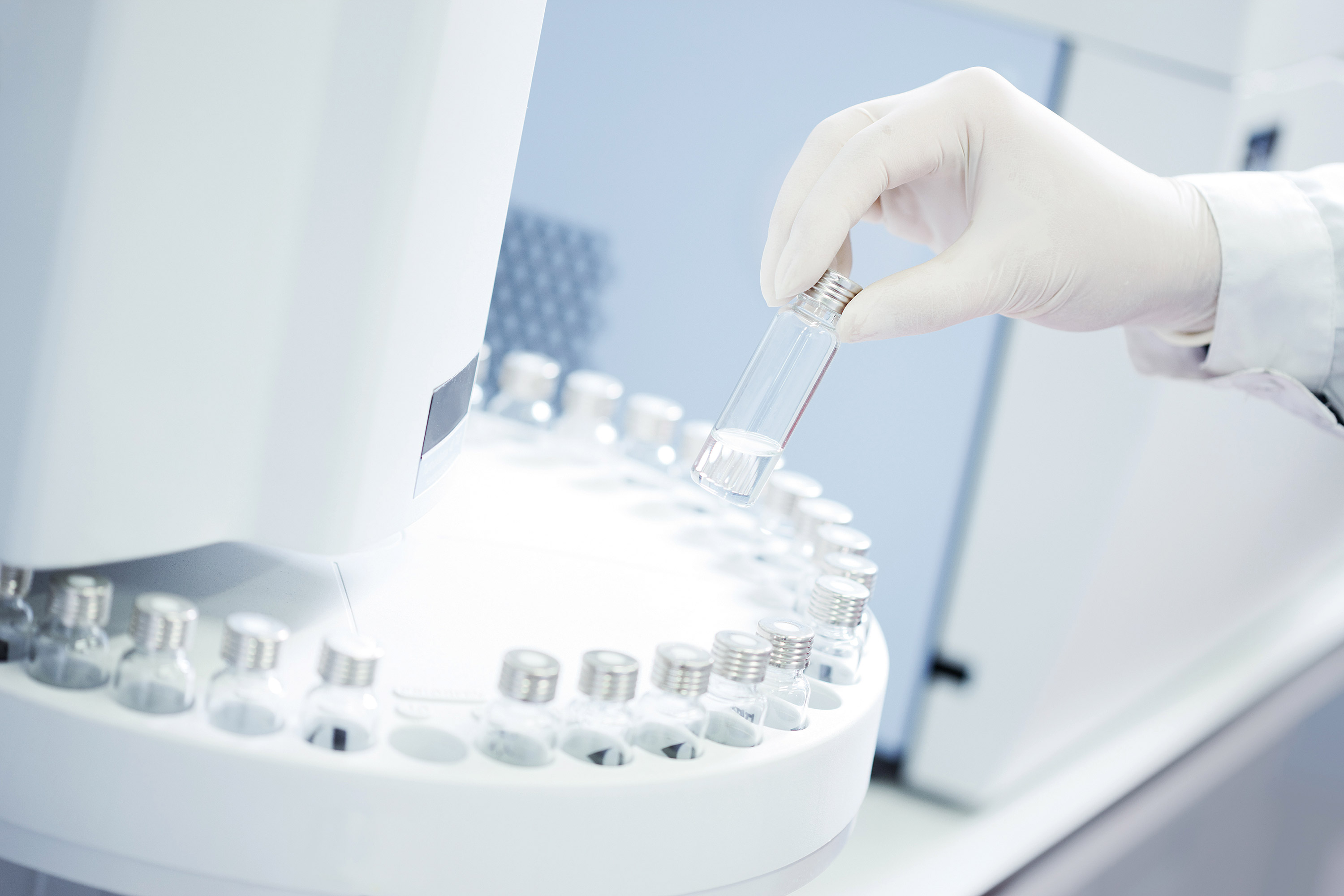 Technician loading sample vials in autosampler rack.