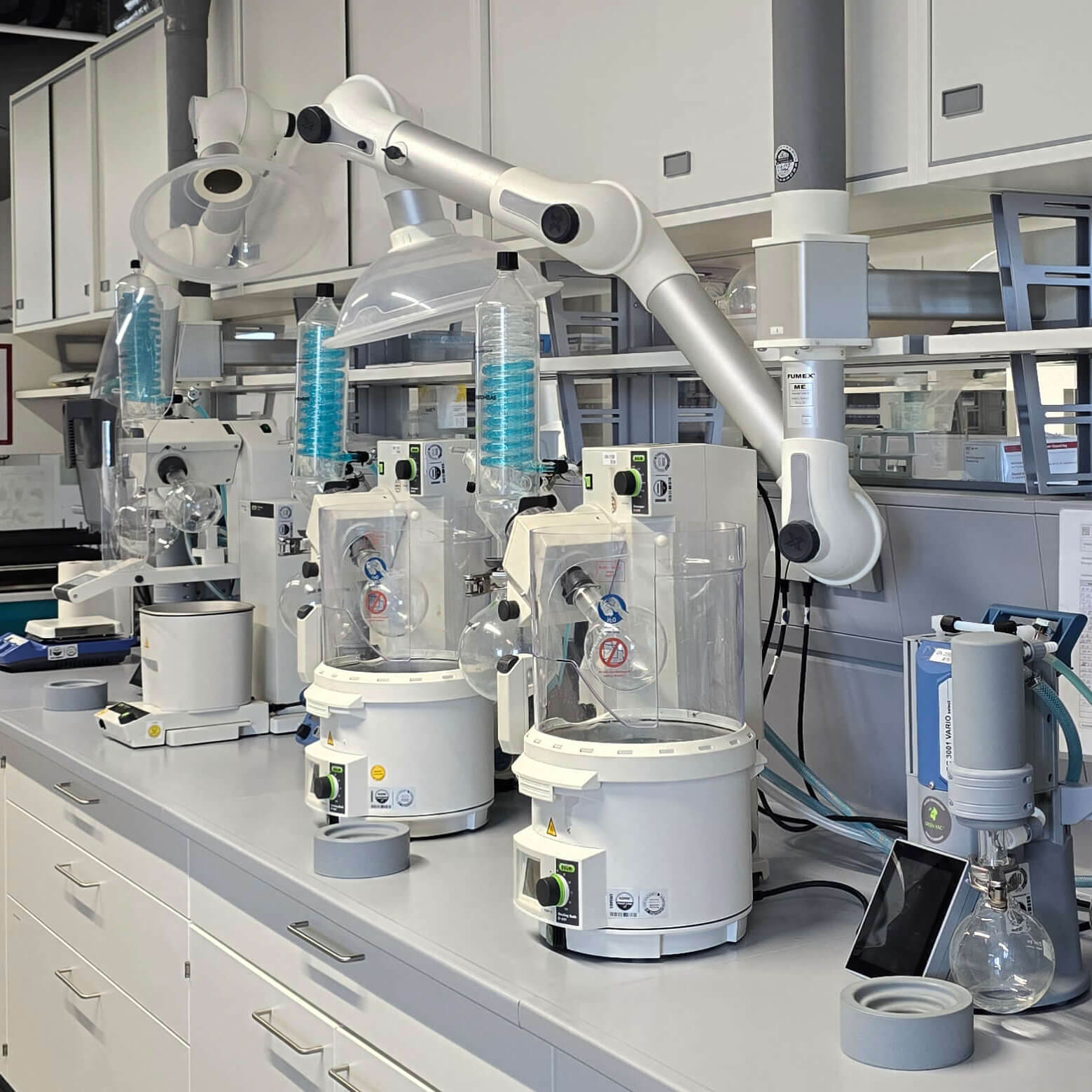 A modern laboratory workspace is equipped with benchtop instruments, extraction units, and organized testing equipment.