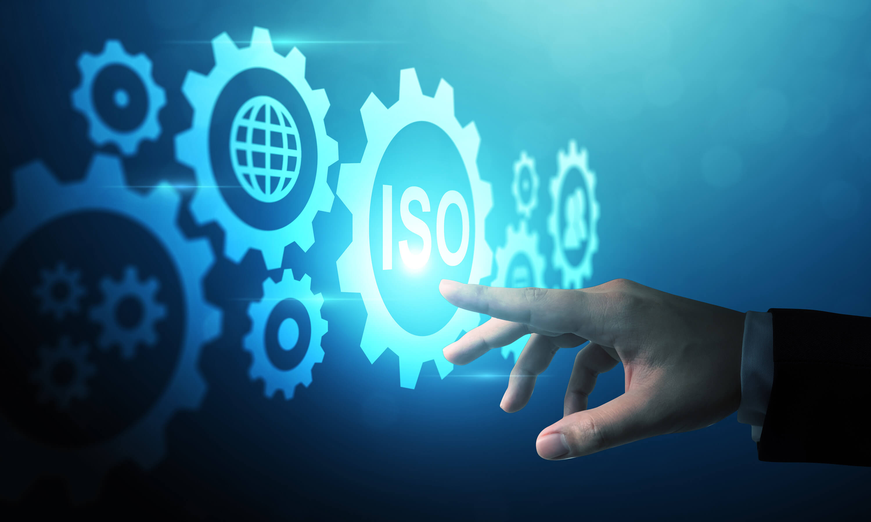 Hand selecting a digital ISO icon surrounded by gear symbols.