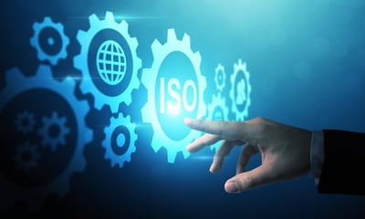 Hand selecting a digital ISO icon surrounded by gear symbols.