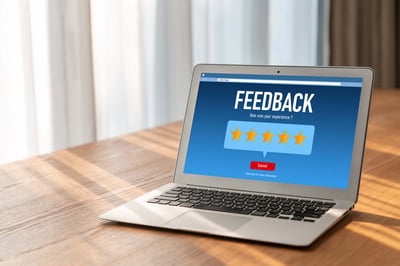 Laptop displaying a customer feedback form with a five-star rating.