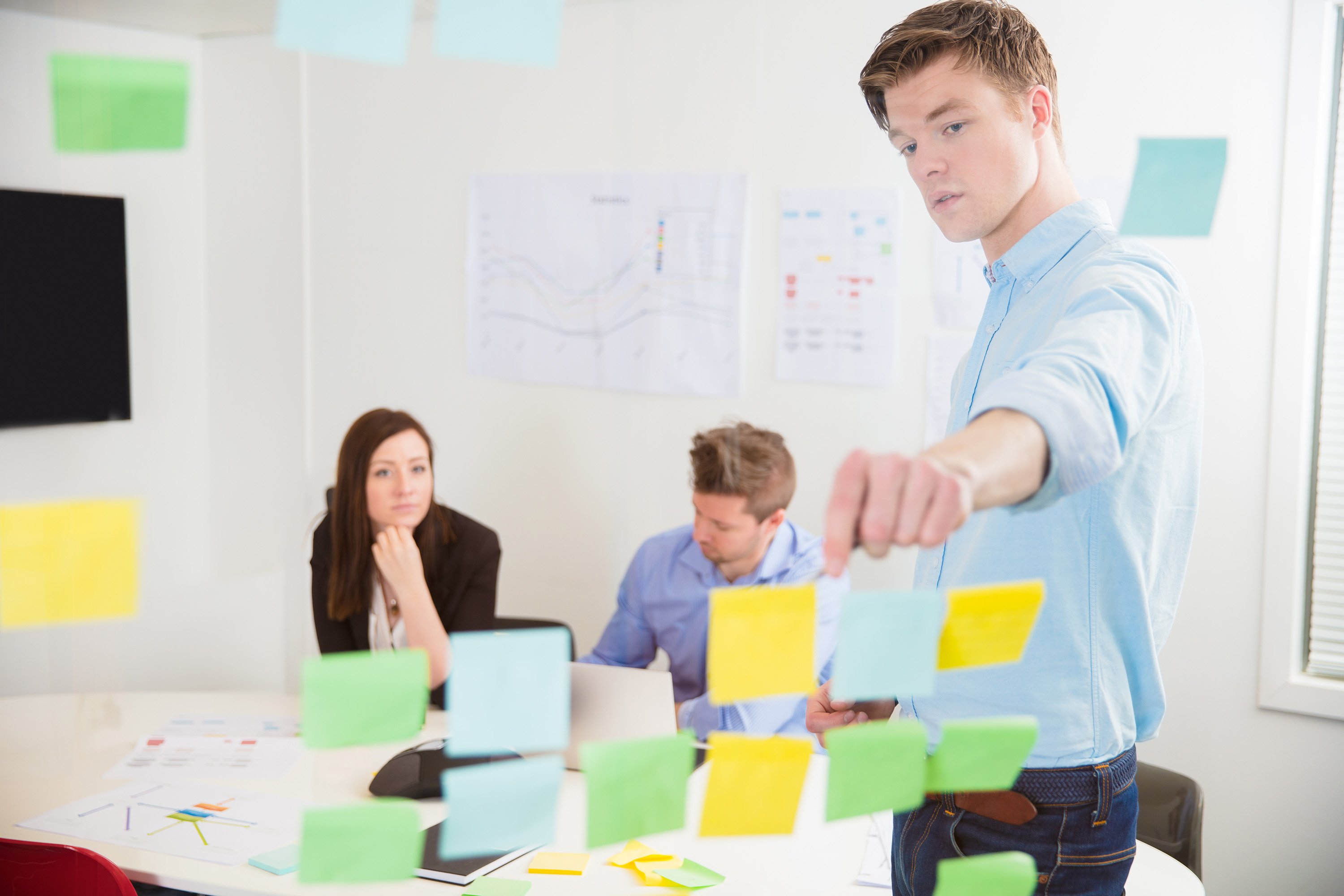 Business team organizing sticky notes during a planning meeting.