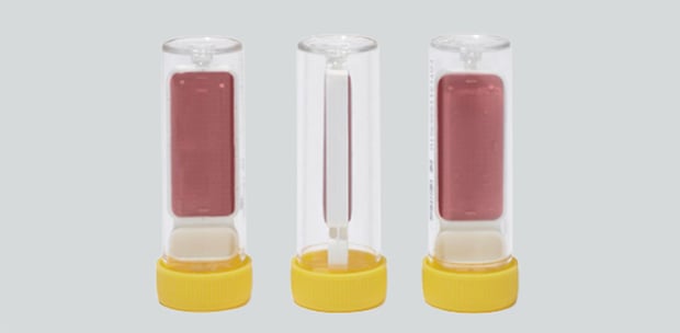 Contact test swabs in transparent tubes with red agar medium for microbiological surface analysis.