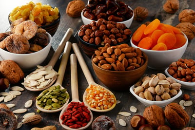 Assorted nuts, seeds, and dried fruits in bowls.
