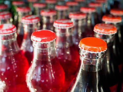 Glass bottles with red caps filled with beverages.