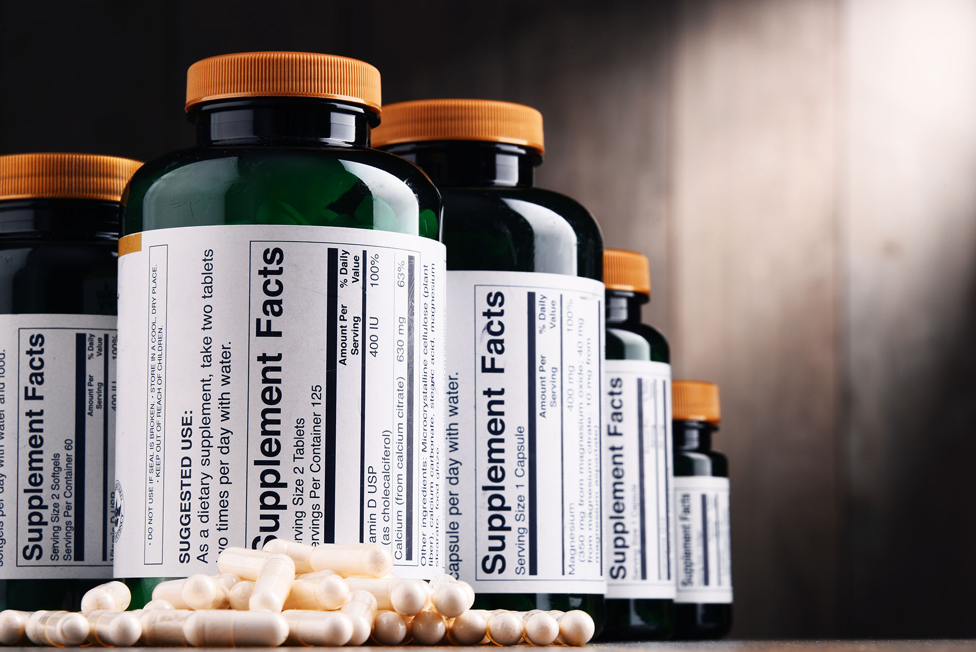 Supplement bottles with capsules on a surface, labeled with nutrition facts.