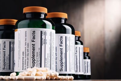 Supplement bottles with capsules on a surface, labeled with nutrition facts.