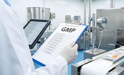Inspector holding clipboard with GMP text in factory,checking good manufacturing practice standards,ensuring quality control,safety compliance,industrial hygiene rules.