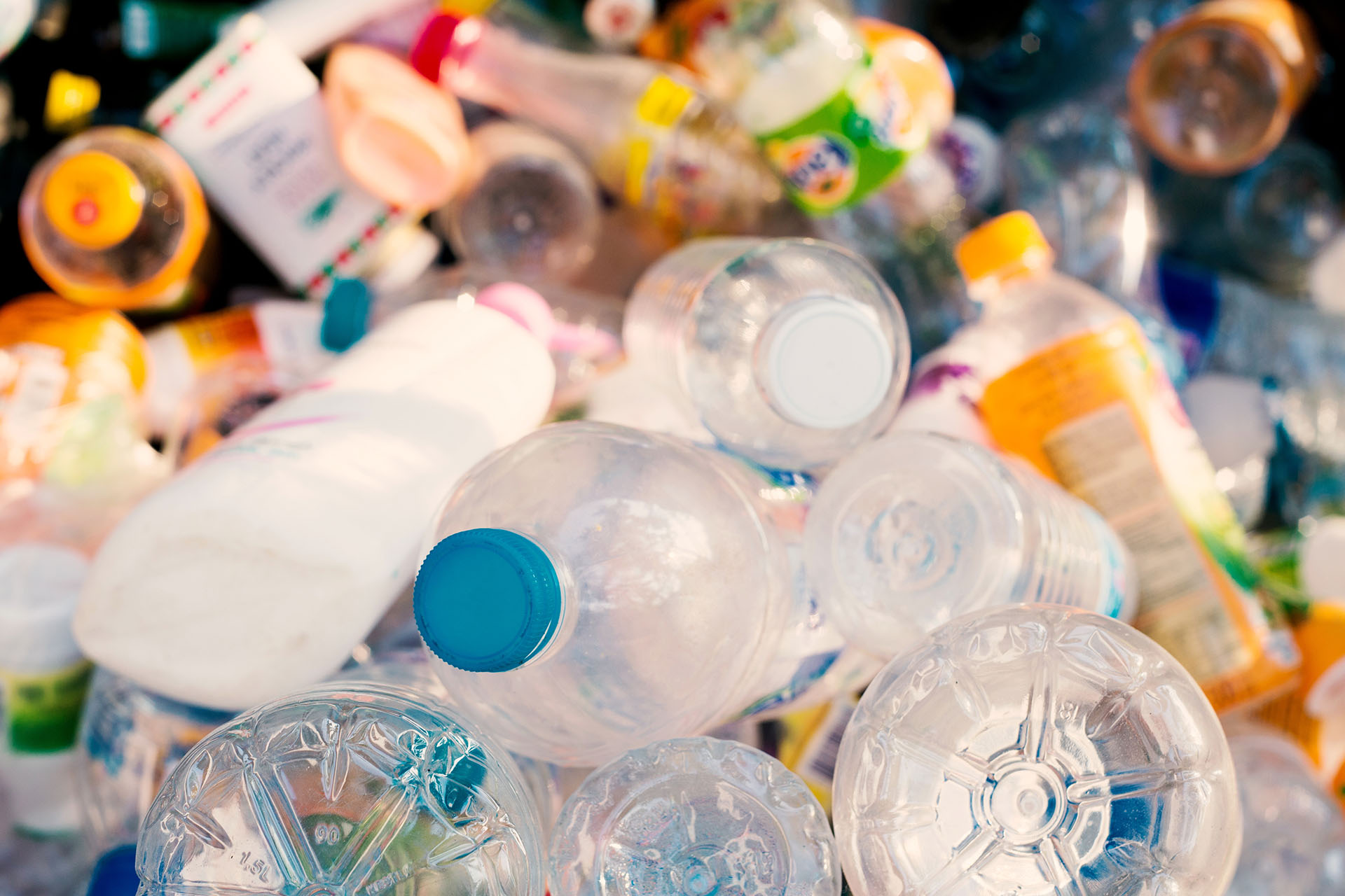 Mixed plastic bottles and containers piled together.