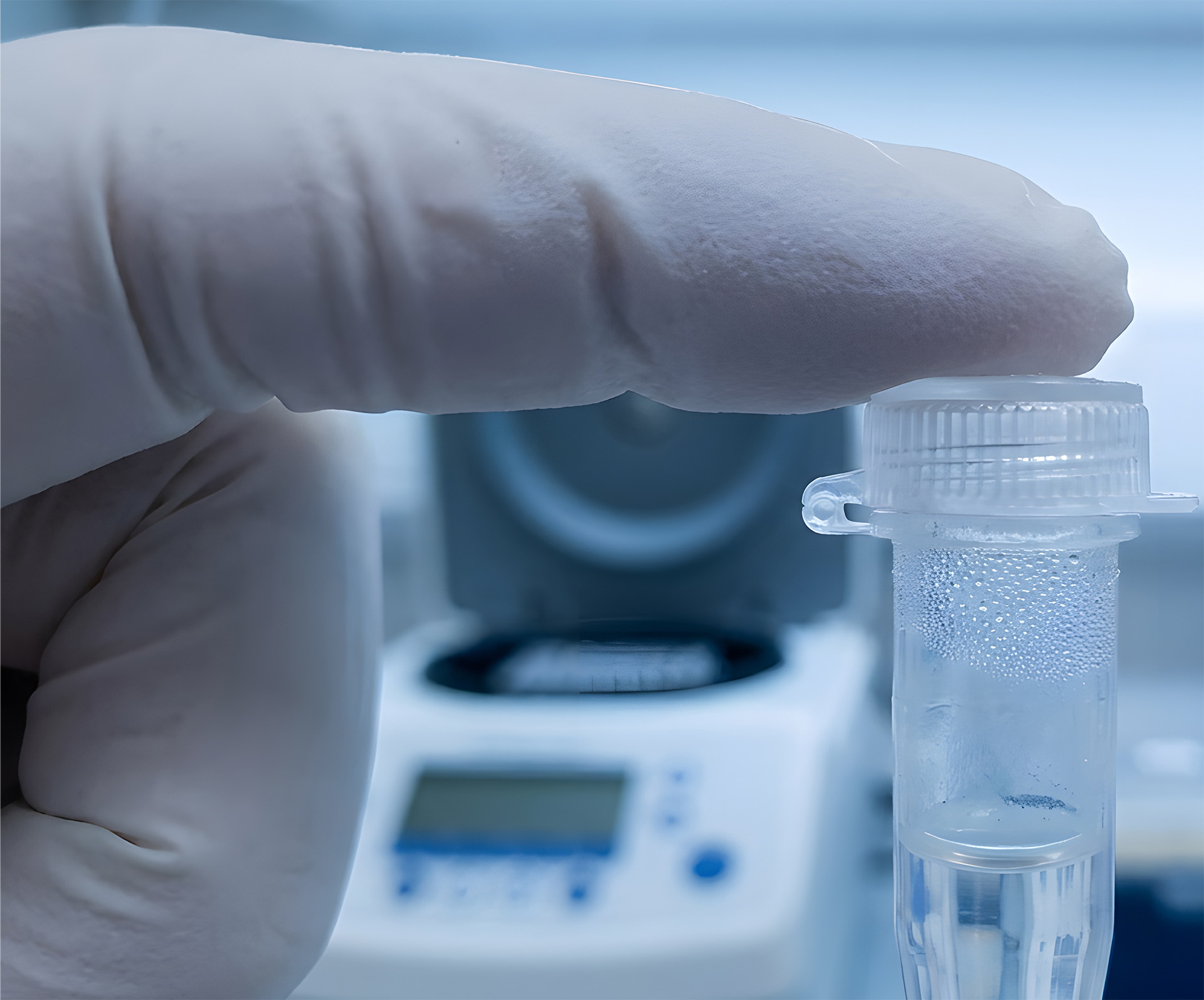Scientist closing PCR tube lid in lab working on molecular biology procedures.
