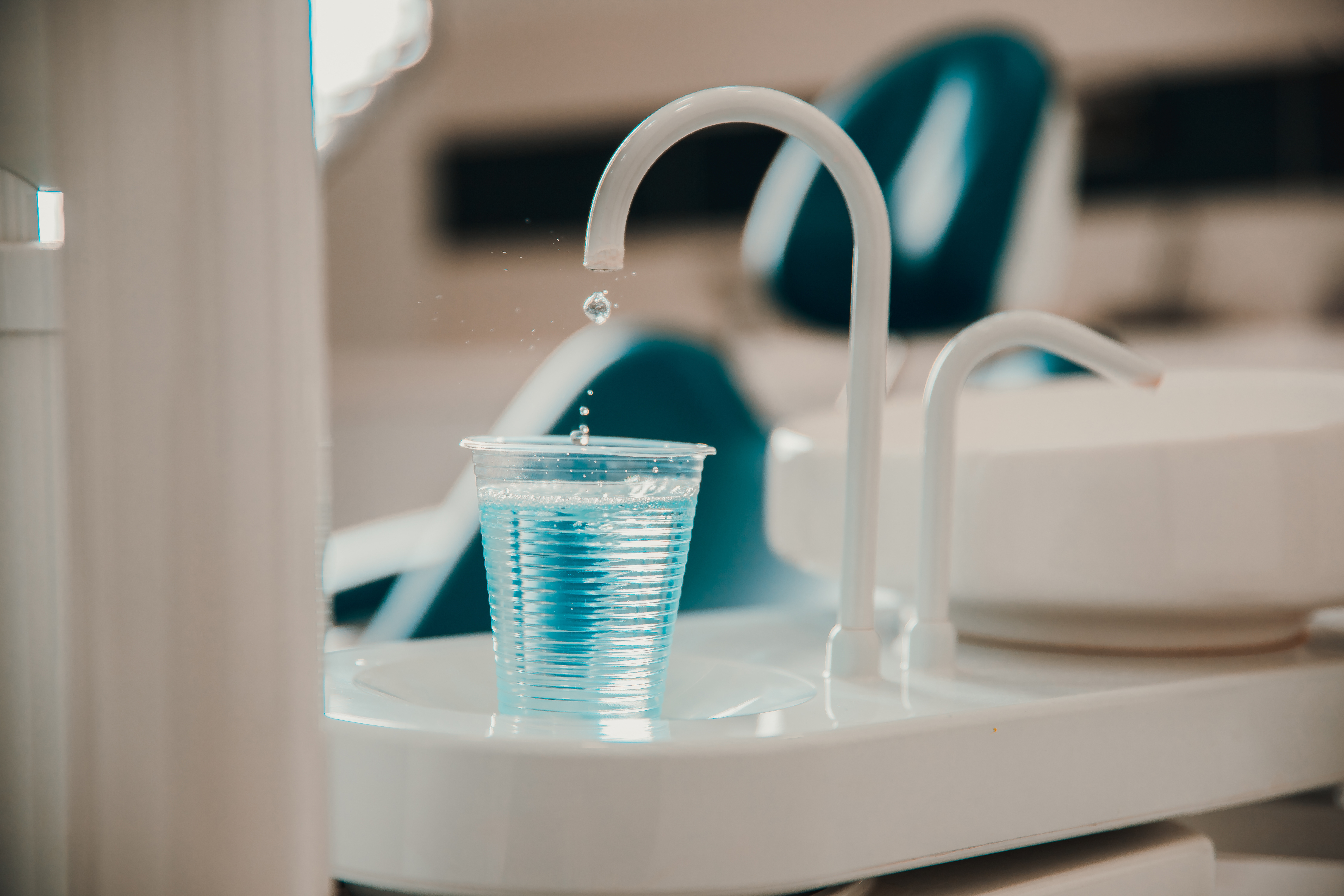 Cup of blue mouthwash in the dentist clinic.