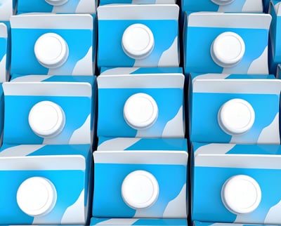 Top-down view of identical blue and white beverage cartons in a tight grid pattern.